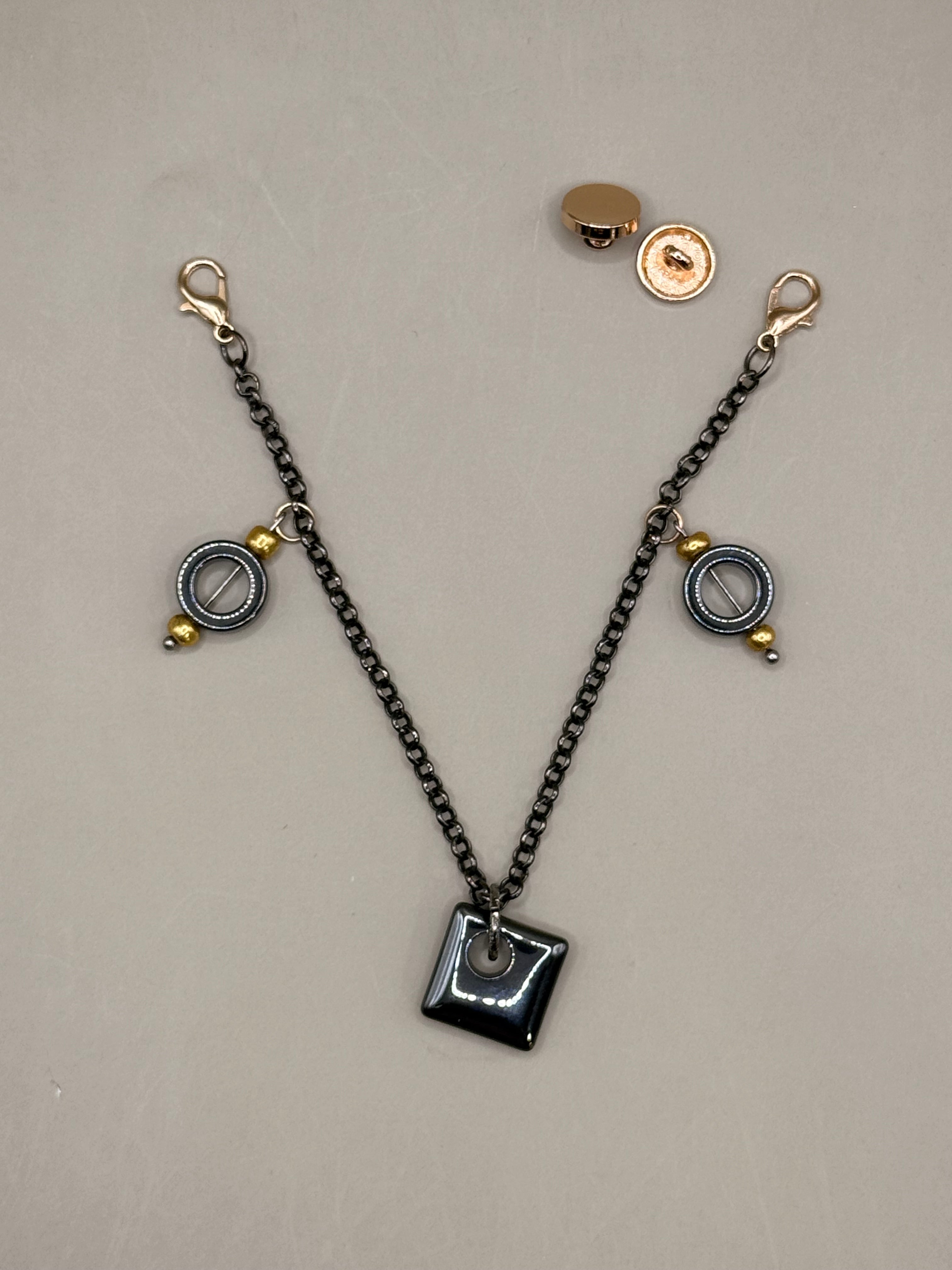 Metallic chain with various charms on a light gray background